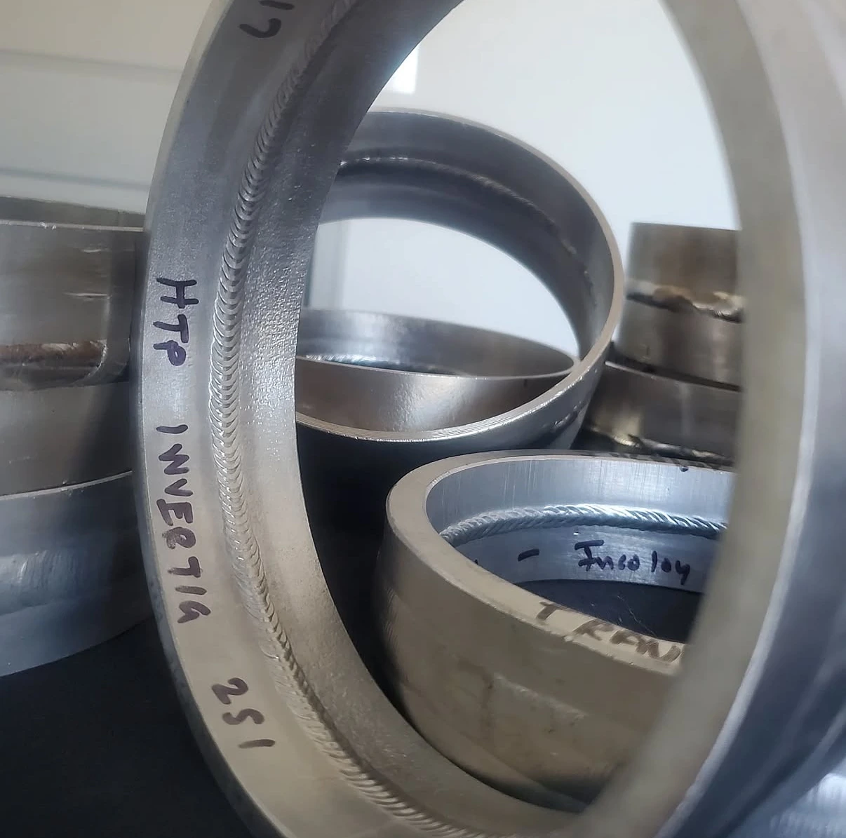 Sectioned pipe weld rings arranged to show internal weld profiles